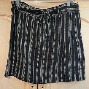 The Loft black and white pull on skirt has a matching tie belt. Size L .